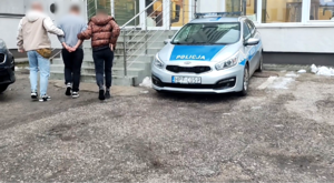 Policjanci prowadzący zatrzymanego.