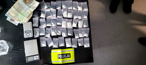 Woreczki foliowe z białym proszkiem, pieniądze i dwie wagi.