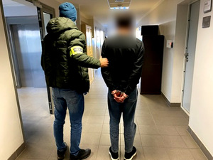 Policjant trzymający zatrzymanego.