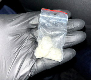 Woreczek z mefedronem na dłoni policjanta.