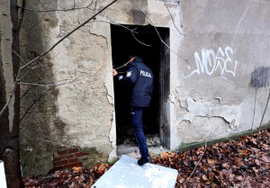 Policjant kontrolujący pustostan.