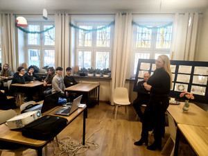 Policjanci, przedstawicielka WORD i uczniowie podczas prelekcji.