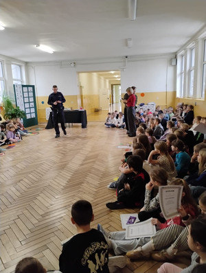 Dzielnicowy z dziećmi podczas prelekcji.