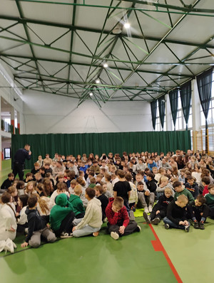 Dzielnicowy z dziećmi podczas prelekcji.