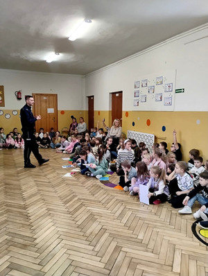 Dzielnicowy z dziećmi podczas prelekcji.