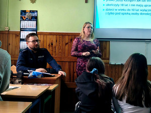 Policjant wraz z kobietą podczas spotkania z uczniami.
