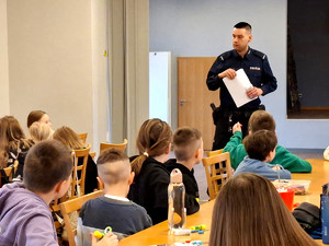 Policjant z dziećmi podczas pogadanki.