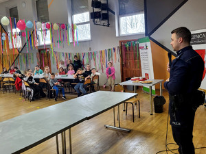 Policjant z dziećmi podczas spotkania profilaktycznego.