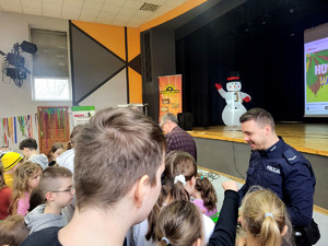 Policjant z dziećmi podczas spotkania profilaktycznego.