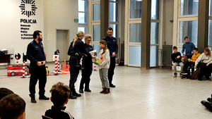 Policjanci z dziećmi podczas ferii w komendzie.