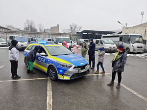 Policjanci z dziećmi podczas ferii w komendzie.