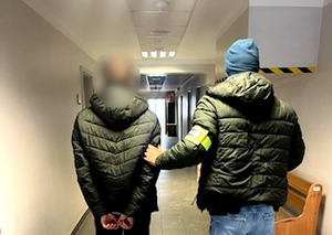 Policjant z zatrzymanym mężczyzną.