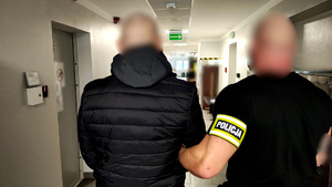 Policjant z zatrzymanym mężczyzną.