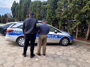 Zatrzymany mężczyzna z policjantem.