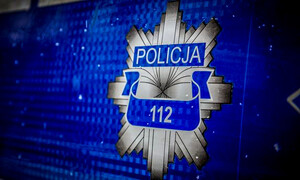 Szara gwiazda policyjna na granatowym tle z napisem policja 112.