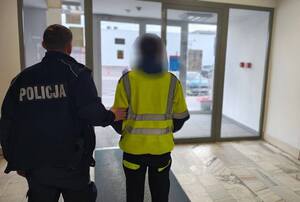 Zatrzymany mężczyzna z policjantem.