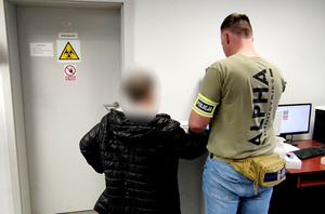 Policjant pobiera od kobiety odciski palców.