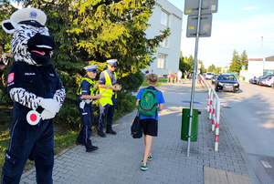Funkcjonariusze i dzieci podczas akcji Bezpieczna droga do szkoły.