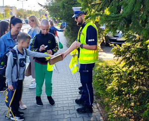Funkcjonariusze i dzieci podczas akcji Bezpieczna droga do szkoły.