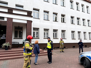Policjanci oraz strażacy podczas ćwiczeń na terenie szkoły.