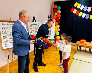 Wójt, dzielnicowy oraz dzieci podczas konkursu.