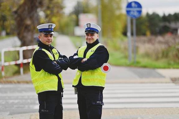 Dwóch policjantów w kamizelkach odblaskowych.