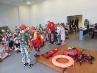dzieci biorą udział  w pokazowej akcji ratowniczej przygoptowanej przez pracowników WOPR