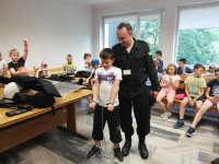 policjant prezentuje dzieciom policyjny sprzęt