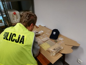 policjant zabezpiecza narkotyki znalezione u podejrzanego