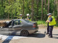 policjanci prowadzą oględziny uszkodzonego samochodu