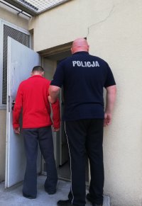 policjant prowadzi zatrzymanego