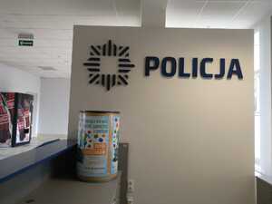 miejsce przy dyzurce z logo policji i pojemniki na zakrętki
